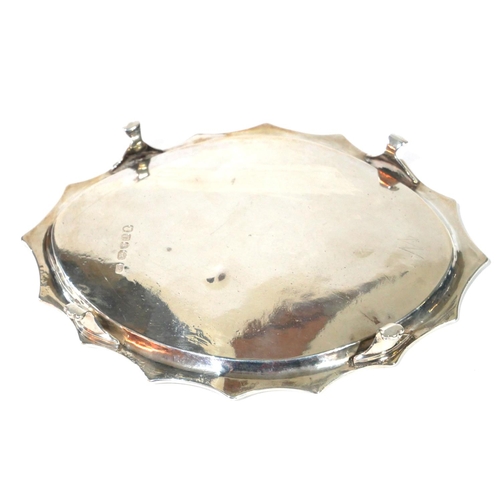 455 - A GEORGIAN SILVER OVAL TEAPOT STAND 
With scalloped edge and engraved border, raised on four lion pa... 