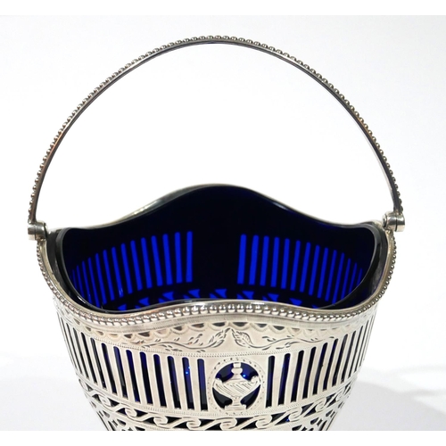 458 - A GEORGIAN SILVER AND BLUE GLASS SWEETMEAT BASKET
Classical form with swing handle and pierced decor... 