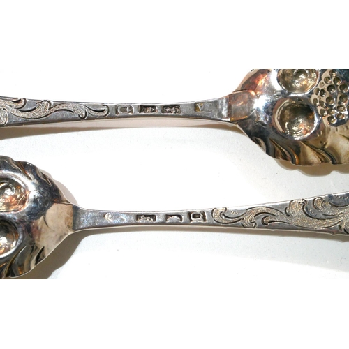 474 - A PAIR OF GEORGIAN SILVER BERRY SPOONS
Having engraved armorial crest to finial and gilt embossed de... 