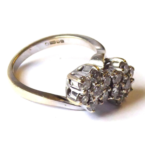 502 - AN 18CT WHITE GOLD AND DIAMOND DOUBLE CLUSTER RING
The arrangement of round cut stones forming two c... 