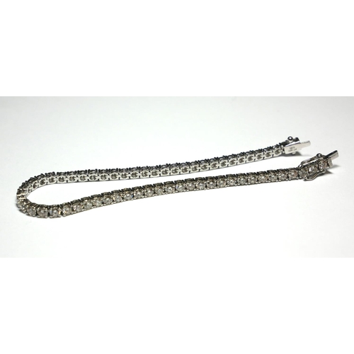 539 - A PLATINUM TENNIS BRACELET
Set with 4.93ct of round cut diamonds. 
(length 19cm) (15.8g)