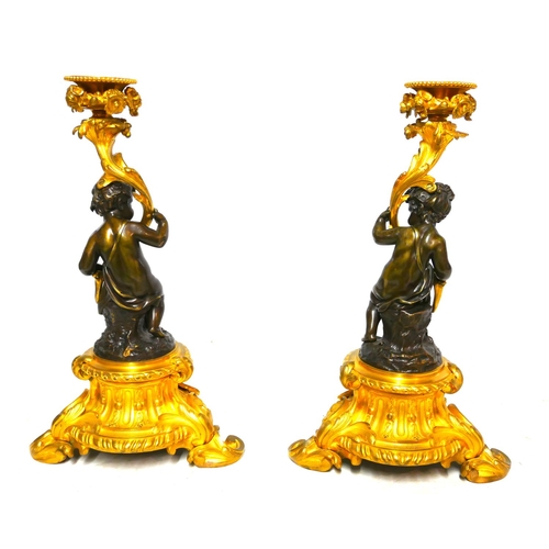 564 - A FINE AND IMPRESSIVE PAIR OF 19TH CENTURY GILT AND PATINATED BRONZE CANDELABRA 
With seated putti s... 