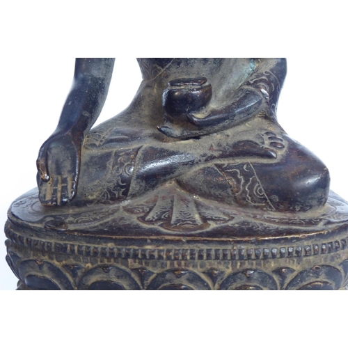 572 - A CHINESE BRONZE BUDDHA
Seated pose with ceremonial vessel and double lotus base 
Bearing a label to... 