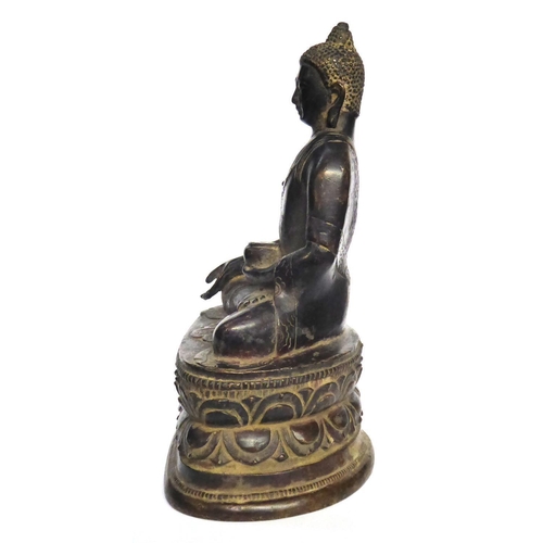 572 - A CHINESE BRONZE BUDDHA
Seated pose with ceremonial vessel and double lotus base 
Bearing a label to... 