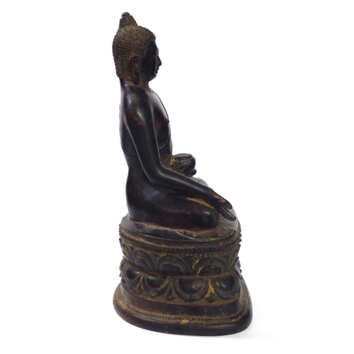 572 - A CHINESE BRONZE BUDDHA
Seated pose with ceremonial vessel and double lotus base 
Bearing a label to... 