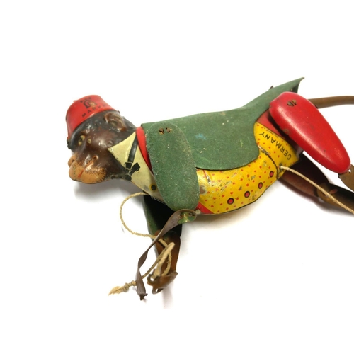 609 - AN EARLY 20TH CENTURY GERMAN TINPLATE CLIMBING MONKEY TOY
Wearing a red fez hat and green jacket.
(a... 