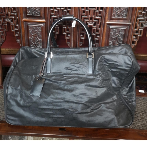 708 - GUCCI, A LARGE BLACK FABRIC HOLDALL BAG
Having a black leather carry handle and monogram pattern
(ap... 
