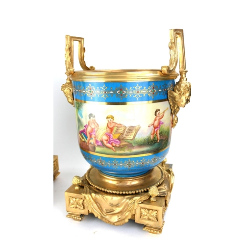 724 - A PAIR OF GILDED BRONZE AND PORCELAIN CACHE POTS
Figured with cherub masks and putti.
(26cm x 34cm)
... 