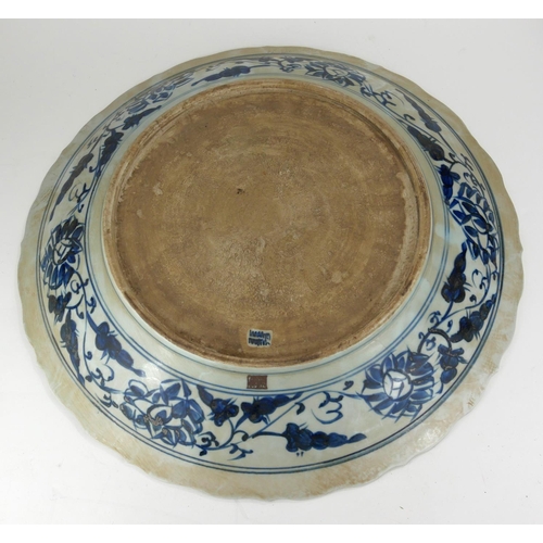726 - A LARGE CHINESE BLUE AND WHITE SHALLOW BOWL 
With cartouche border, decorated with clouds and floral... 
