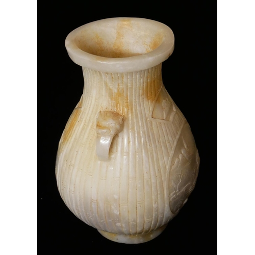 733 - A CHINESE WHITE JADE BALUSTER VASE
With mask handles and carved bamboo design and having a circular ... 