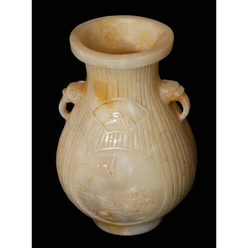 733 - A CHINESE WHITE JADE BALUSTER VASE
With mask handles and carved bamboo design and having a circular ... 