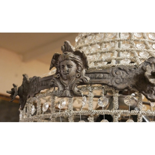 757 - A CONTINENTAL PLANISHED METAL AND GLASS PRISM BASKET CHANDELIER
Banded with facial masks and florets... 
