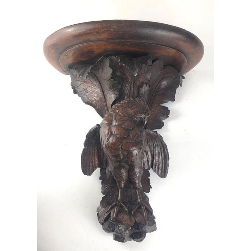 806 - A 19TH CENTURY SWISS CARVED OAK WALL BRACKET
Finely carved with a bird of prey, beneath scrolling oa... 