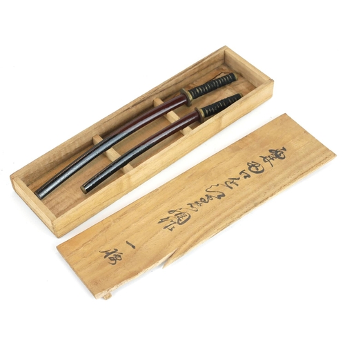 249 - A PAIR OF JAPANESE MINIATURE SAMURAI SWORDS
Having shagreen handles and black lacquer scabbards, in ... 