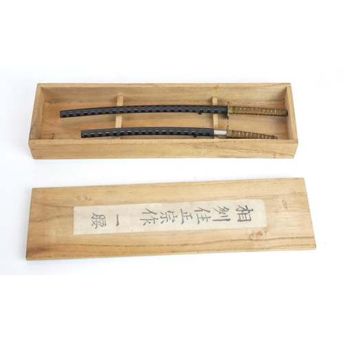 250 - A PAIR OF JAPANESE MINIATURE SAMURAI SWORDS
Having shagreen handles and black lacquer scabbards, in ... 