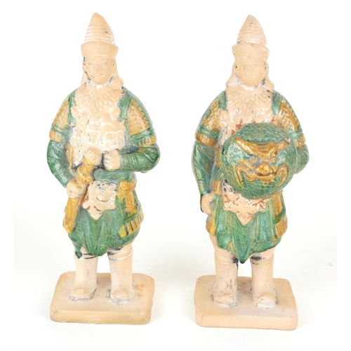 260 - A PAIR OF CHINESE SANCAI GLAZED POTTERY WARRIOR FIGURES
Standing pose, clutching a dragon mask shiel... 