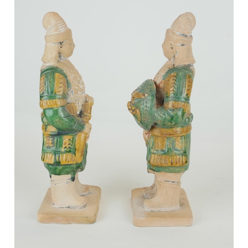 260 - A PAIR OF CHINESE SANCAI GLAZED POTTERY WARRIOR FIGURES
Standing pose, clutching a dragon mask shiel... 