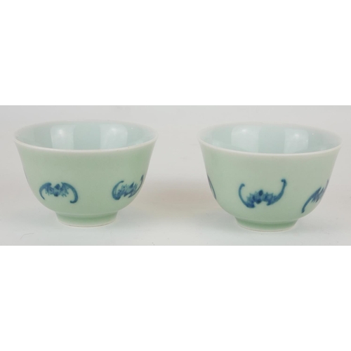295 - A PAIR OF CHINESE CELEDON GLAZE 'BAT' CUPS
Having hand painted underglaze blue bats and square mark ... 