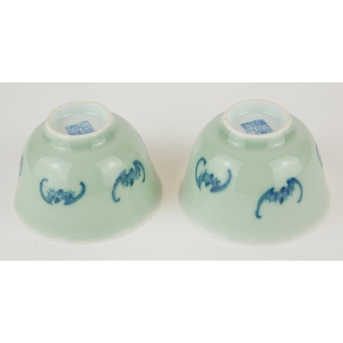 295 - A PAIR OF CHINESE CELEDON GLAZE 'BAT' CUPS
Having hand painted underglaze blue bats and square mark ... 
