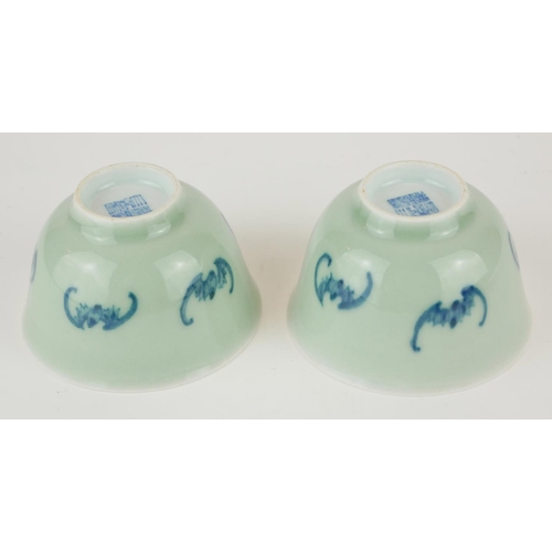 295 - A PAIR OF CHINESE CELEDON GLAZE 'BAT' CUPS
Having hand painted underglaze blue bats and square mark ... 