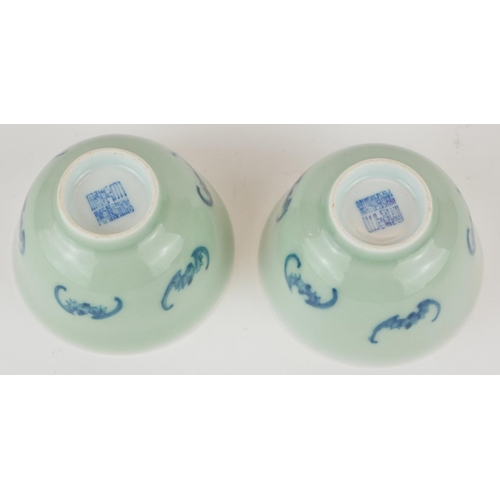295 - A PAIR OF CHINESE CELEDON GLAZE 'BAT' CUPS
Having hand painted underglaze blue bats and square mark ... 