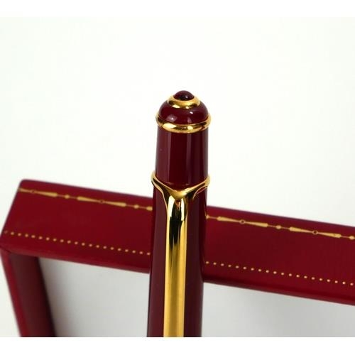 247a - CARTIER, A CASED FULL SIZE GOLD PLATED STYLO DIABOLO BALLPOINT PEN
Bordeaux finish with cabochon cut... 