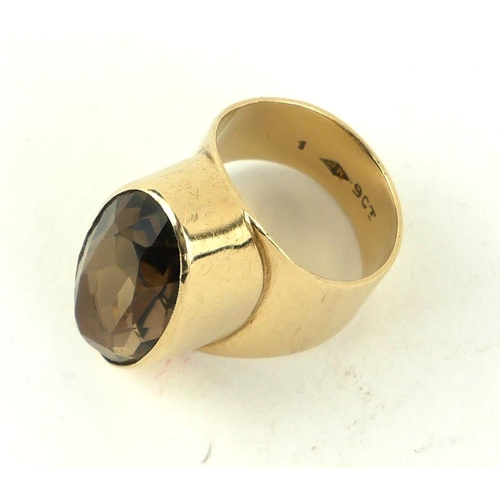 306a - AN EARLY 20TH CENTURY 9CT GOLD AND SMOKY QUARTZ BAND RING
The oval faceted cut stone (size N).