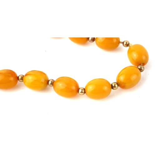 341 - AN EARLY 20TH CENTURY BUTTERSCOTCH AMBER BEAD NECKLACE
Having a single row of oval beads with yellow... 