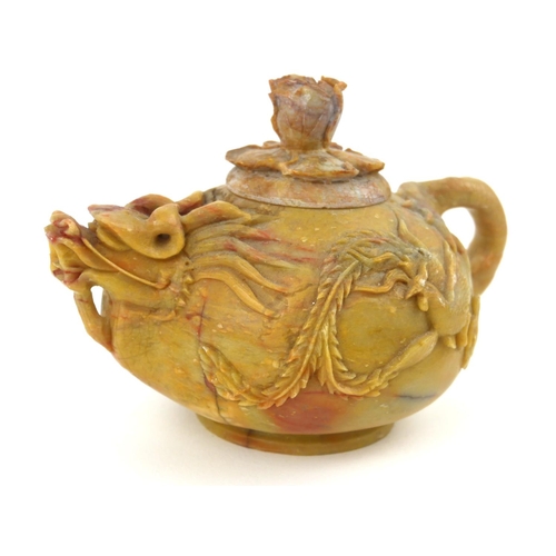 413 - AN EARLY QING DYNASTY CHINESE SOAPSTONE DRAGON TEAPOT AND COVER
The ovoid body with delicate spout a... 