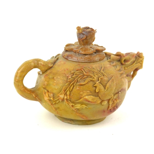 413 - AN EARLY QING DYNASTY CHINESE SOAPSTONE DRAGON TEAPOT AND COVER
The ovoid body with delicate spout a... 