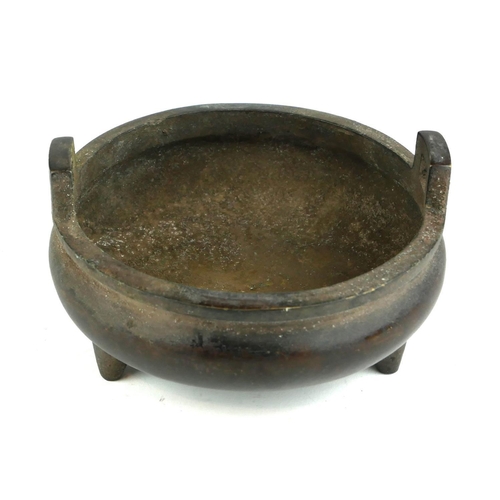 415B - A CHINESE BRONZE TWIN HANDLED CENSOR 
Raised on three squat legs, bearing a six character mark.
(8cm... 