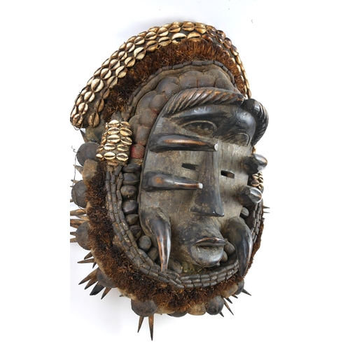 424 - A COLLECTION OF FOUR 20TH CENTURY CARVED WOODEN AFRICAN TRIBAL ART MASKS
Including a mask with appli... 