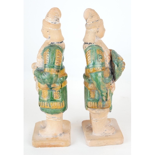 470 - A PAIR OF CHINESE SANCAI GLAZED POTTERY WARRIOR FIGURES
Standing pose, clutching a dragon mask shiel... 