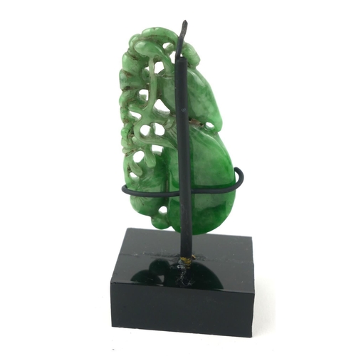 481 - A CHINESE JADE CARVING OF EXOTIC FRUIT
A graduated strand of fruit on a pierced branch, on a black p... 