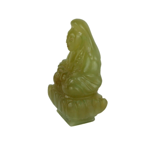 490A - A CHINESE CARVED JADE FIGURE OF A SEATED BUDDHA
Clutching a peach on a lotus flower base.
(approx 7.... 