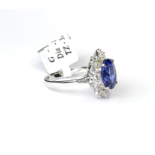 250A - AN 18CT WHITE GOLD, TANZANITE AND DIAMOND CLUSTER RING
The single oval cut tanzanite stone edged wit... 