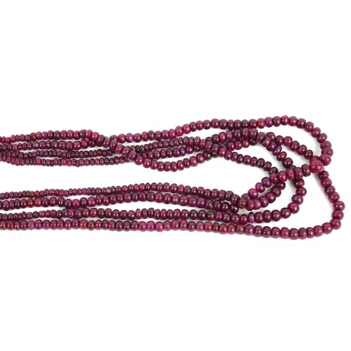 243a - AN INDIAN CARVED  RUBY NECKLACE
Four strands of graduating beads with gilt wire tassel.
(rubies appr... 