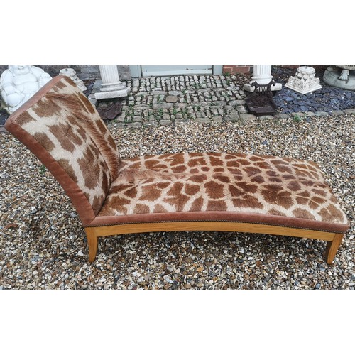 841 - A GIRAFFE SKIN UPHOLSTERED DAYBED
On a honey oak base, supported on square splayed legs.
(142cm x 54... 