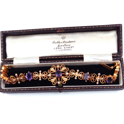 126a - A 22CT GOLD, AMETHYST AND SEED PEARL BRACELET
Having a central oval cut amethyst in a pierced frame,... 