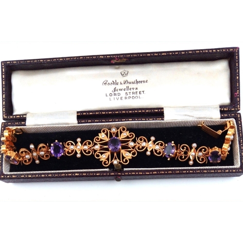 126a - A 22CT GOLD, AMETHYST AND SEED PEARL BRACELET
Having a central oval cut amethyst in a pierced frame,... 