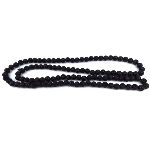 129a - A CHINESE CARVED WOODEN BEAD NECKLACE
The single strand of ebonised beads. 
(approx 65cm)