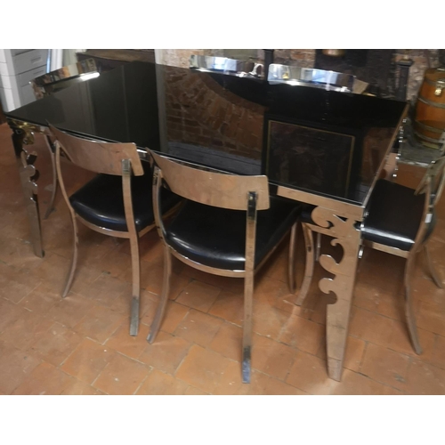 669 - A POLISHED CHROME DINING SUITE
Comprising a black glass top table and six black faux leather upholst... 