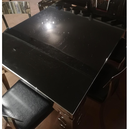 669 - A POLISHED CHROME DINING SUITE
Comprising a black glass top table and six black faux leather upholst... 