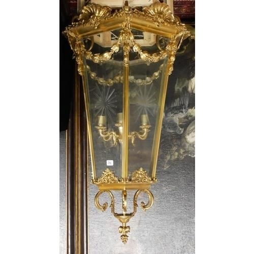 675 - A LARGE POLISHED BRASS LANTERN
The hexagonal tapering etched glazed panels above swags, shell and sc... 