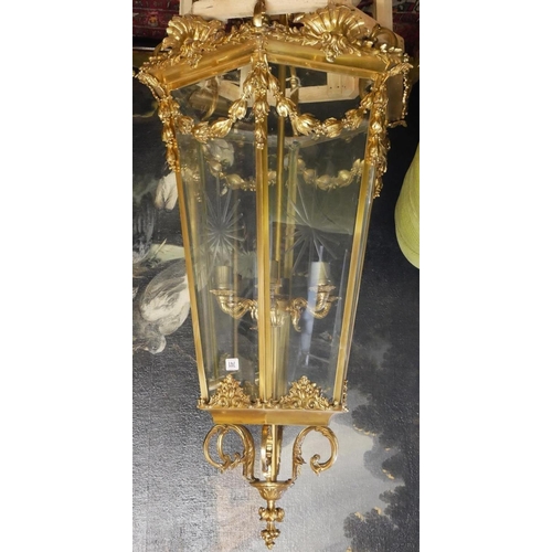 676 - A LARGE POLISHED BRASS LANTERN
The hexagonal tapering etched glazed panels above swags, shells and s... 