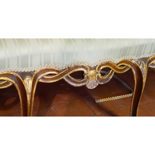 687 - AN 18TH CENTURY ITALIAN WALNUT AND PARCEL GILT OPEN ARM CHAIR SETTEE
With pierced strap work back an... 