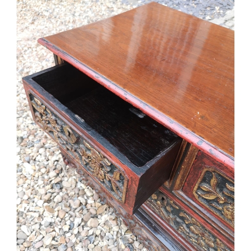 690a - A 19TH CENTURY CHINESE LOW CHEST OF TWO SHORT ABOVE ONE LONG DRAWER
With red lacquered and organic c... 