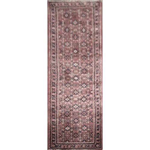 694 - AN IRANIAN WOOLLEN RUNNER
With floral field on a red ground.
(85cm x 236cm)