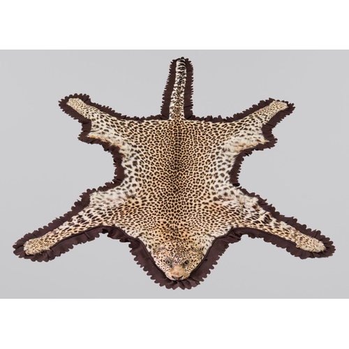 24 - EDWARD GERRARD & SONS, AN EARLY 20TH CENTURY TAXIDERMY LEOPARD SKIN RUG WITH PARTIALLY MOUNTED HEAD ... 