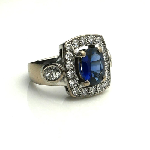 387 - A FRENCH 18CT WHITE GOLD, SAPPHIRE AND DIAMOND RING
The single oval cut sapphire edged with round cu... 